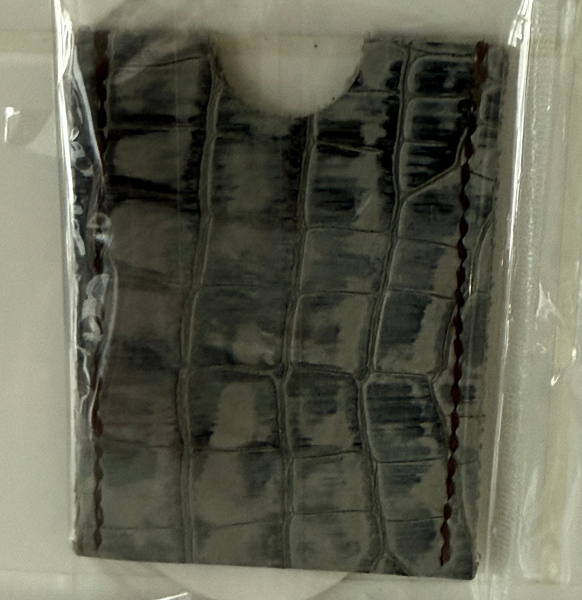 Slim leather card sleeve made from 100% cow hide with textured surface and stitched edges